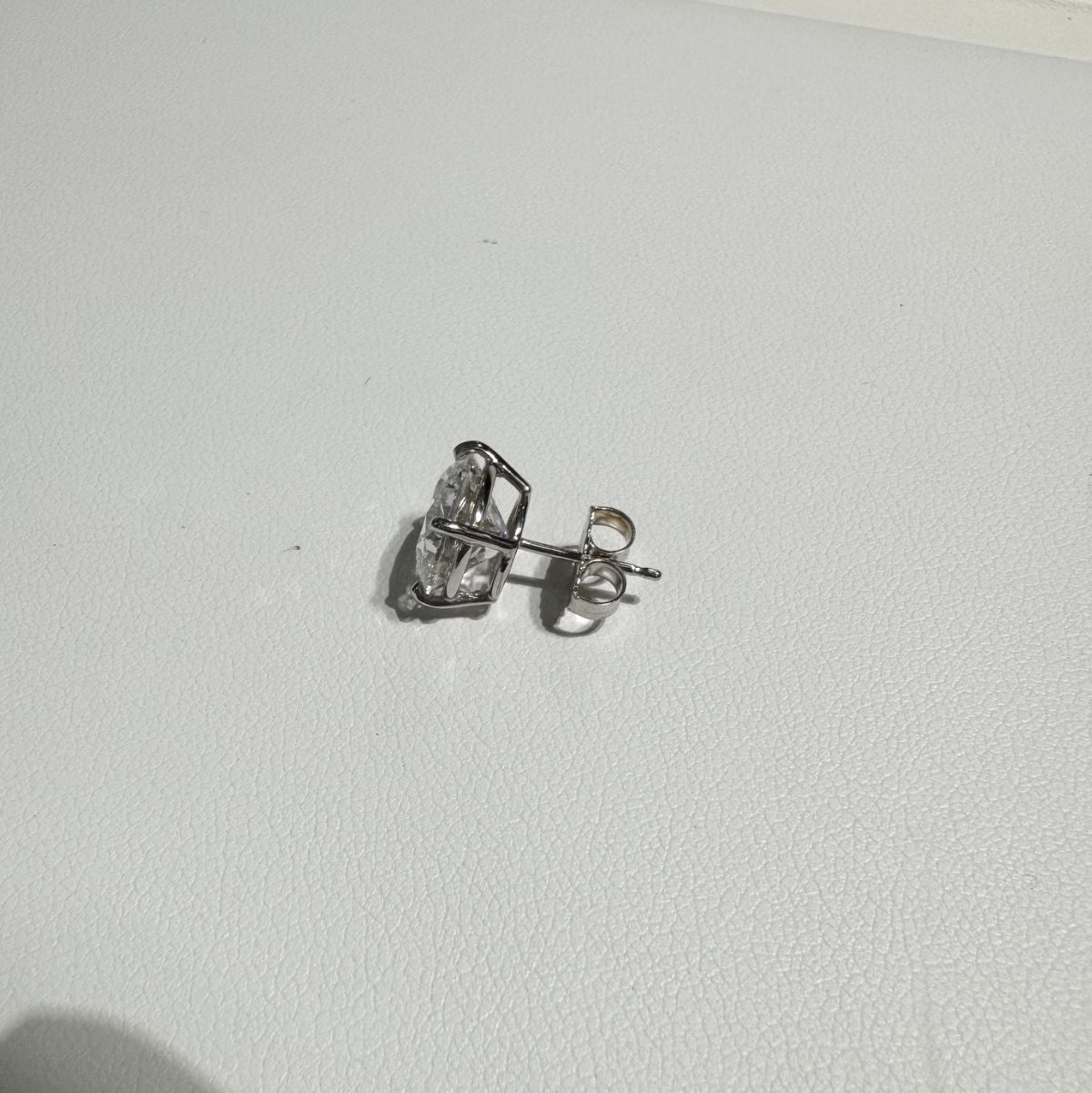 Close-up of a four-prong clear stone stud earring